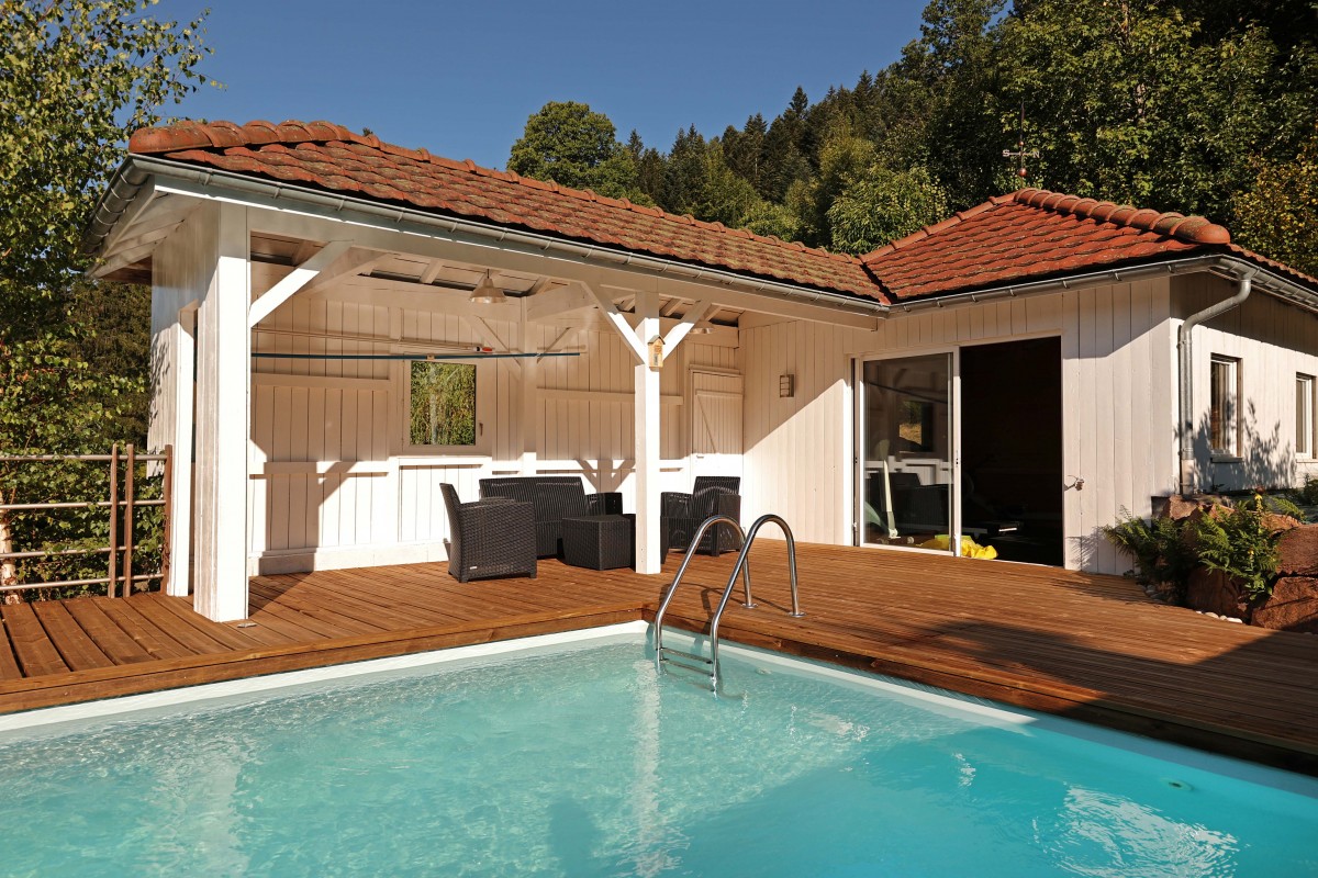 Vue de la piscine extérieure avec son pool-house et l'entrée de la salle de sport