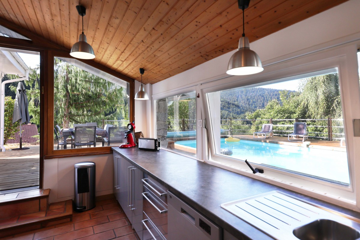 De grandes fenêtres de la cuisine donnent une belle lumière toute l'année avec une vue sur la piscine.